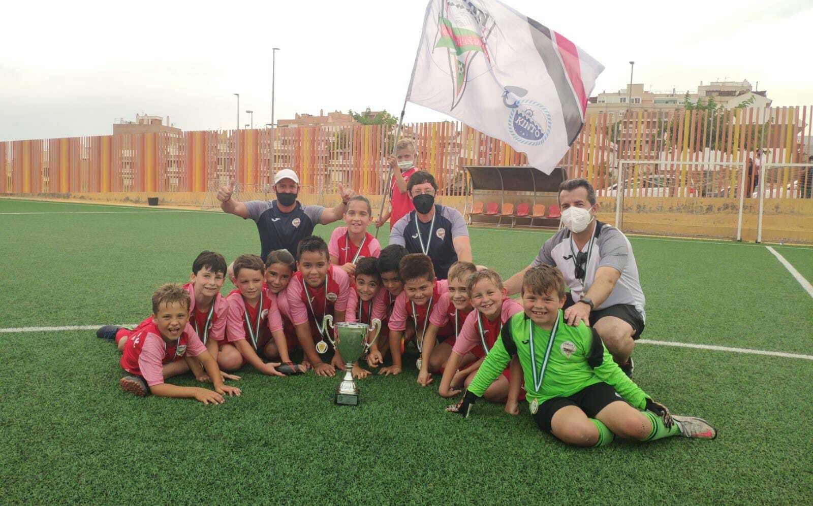Pequeñas figuras de La Cañada con su 'staff' técnico y la Copa de campeones