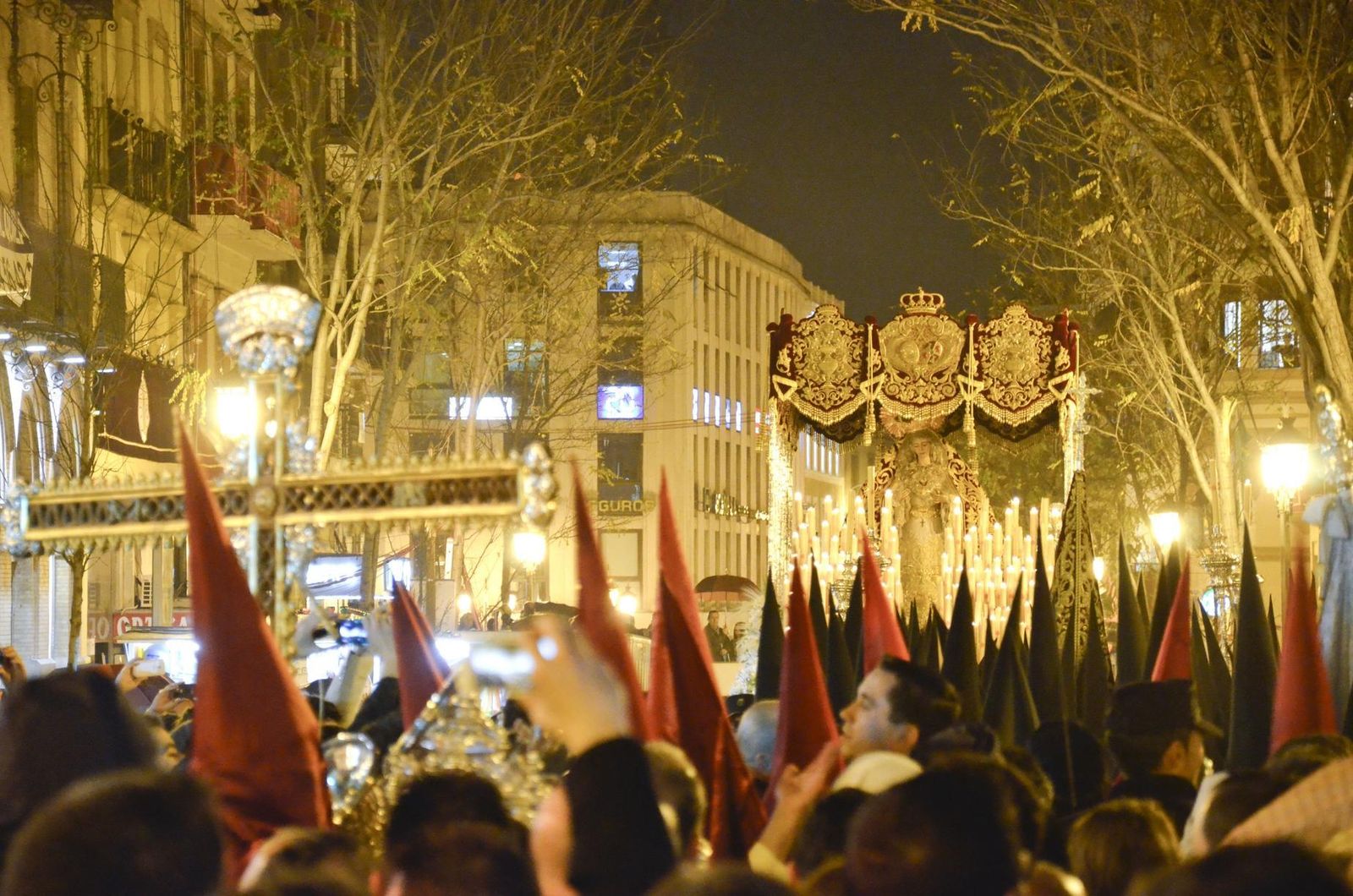 La cruz de guía de la Lanzada aguarda impaciente a que el palio de la Virgen de Regla deje libre la calle Laraña.