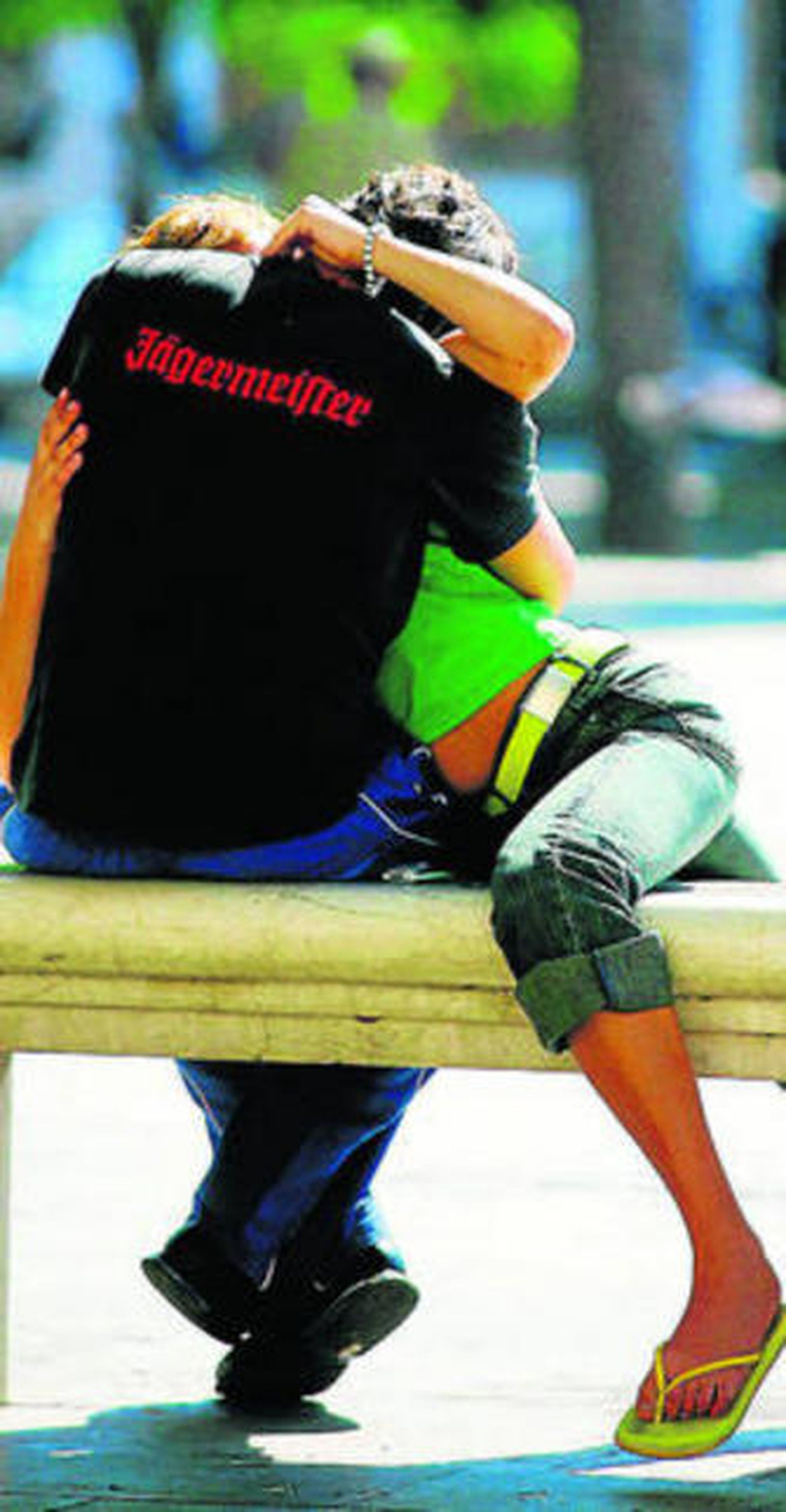 Una pareja se besa en un banco. No mire más de treinta segundos.