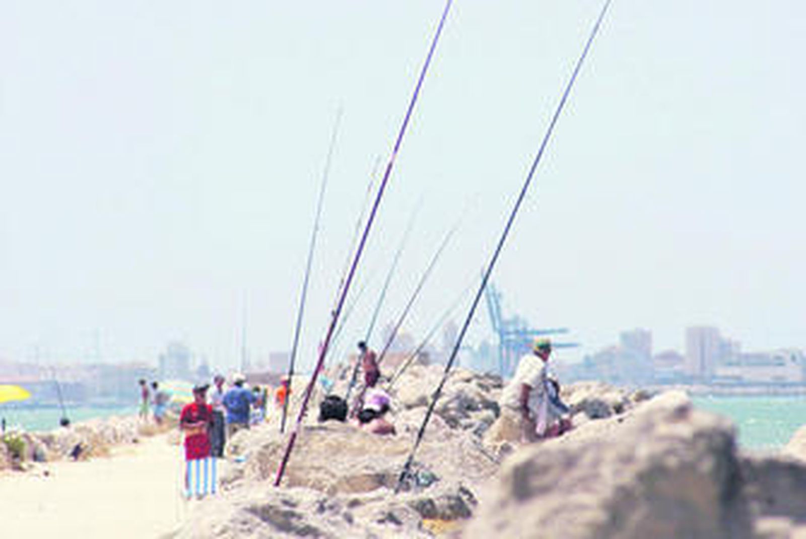 Una fila de cañas en el espigón de la playa de La Puntilla de El Puerto.