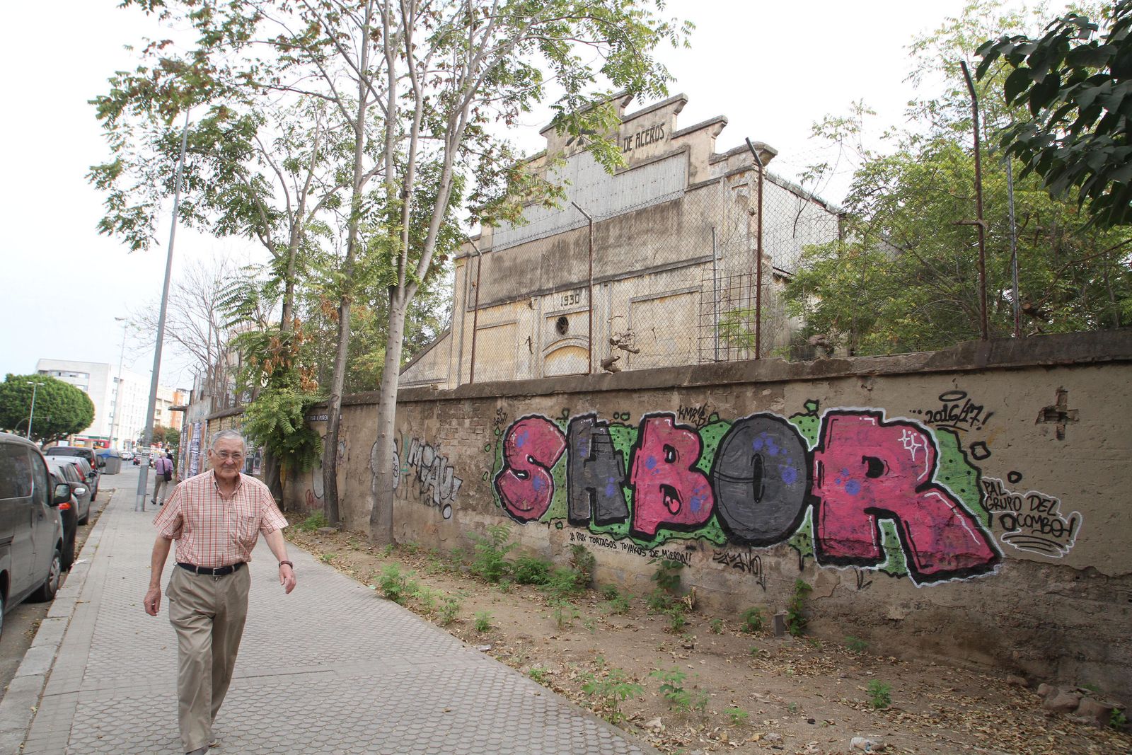 Un hombre camina por la acera a la altura de las naves militares de Santa Bárbara, en el barrio de Nervión.