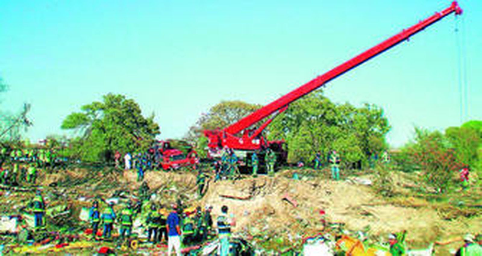 Bomberos y  agentes de la Guardia Civil inspeccionan el lugar el día del accidente.