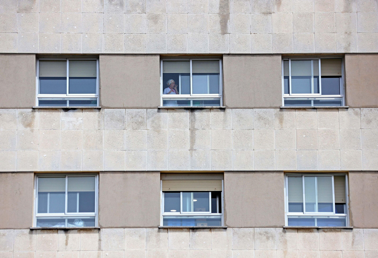 Un sanitario en una ventana del Hospital Punta de Europa de Algeciras.