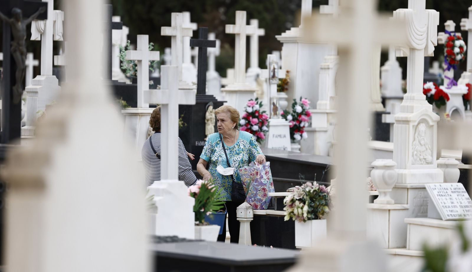 Dos mujeres se saludan en el cementerio de Sevilla en vísperas de Todos los Santos.