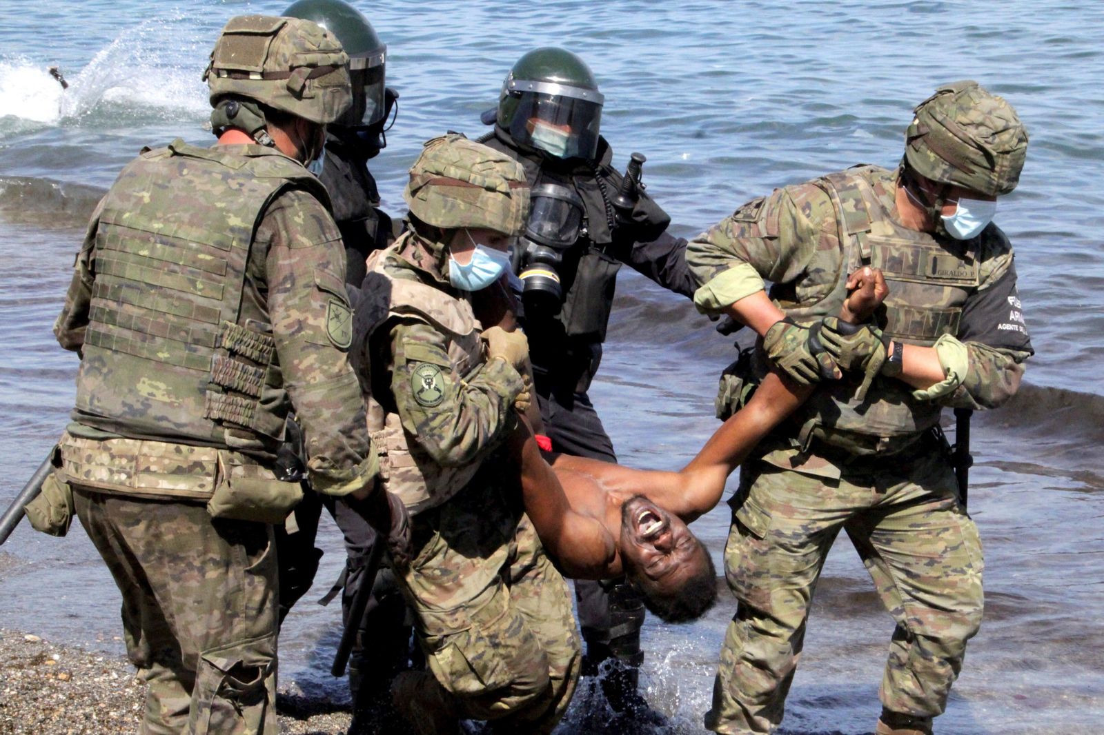 Soldados españoles y Cruz Roja con un inmigrante ayer en Ceuta.