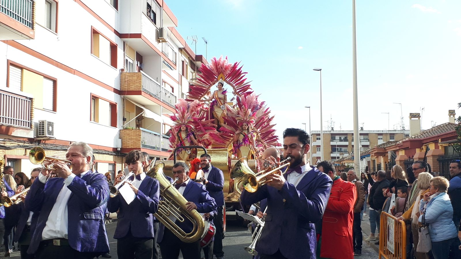 La carroza de la corte juvenil, precedida de una charanga.