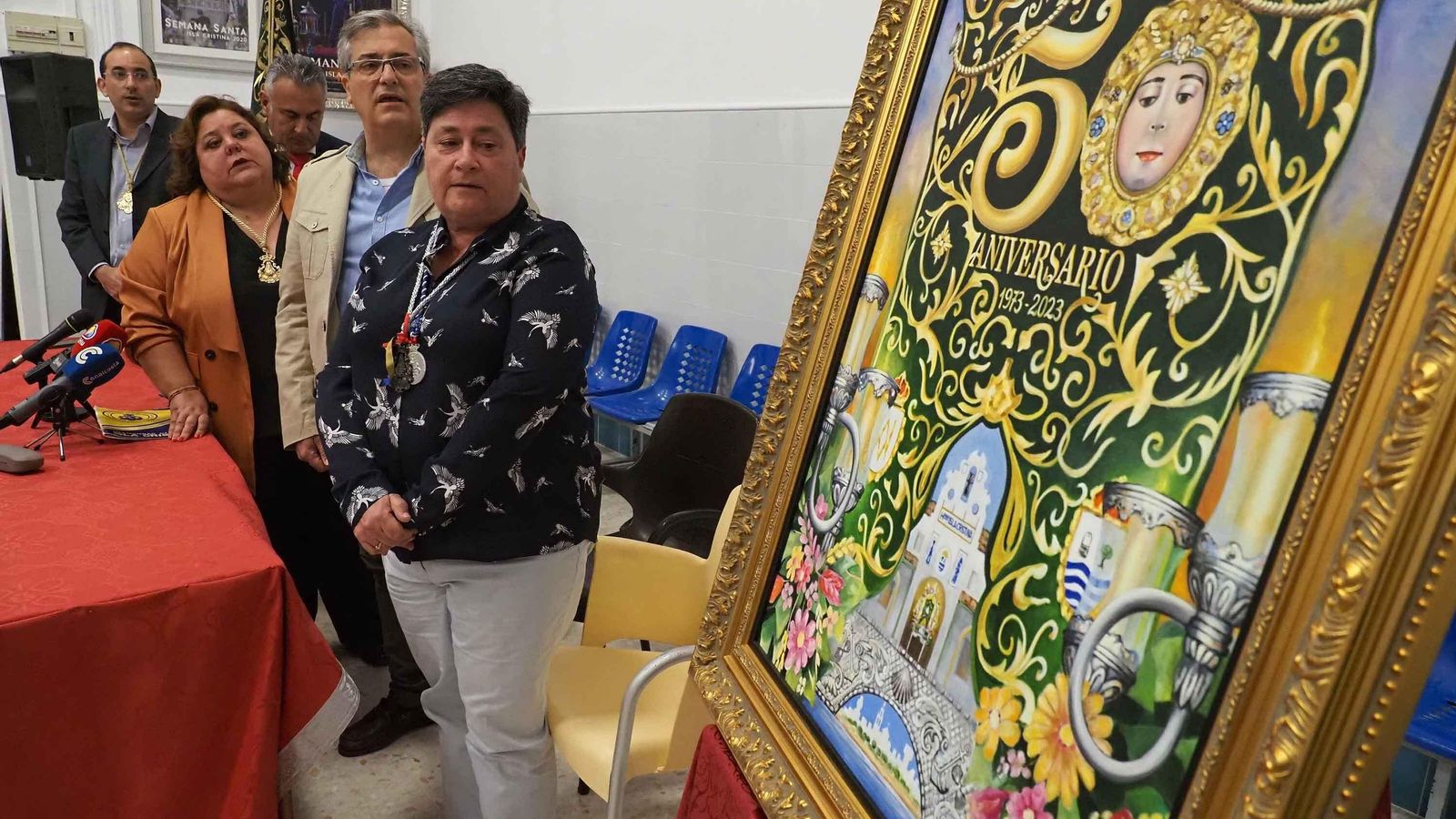 Los protagonistas del acto rezan una salve rociera ante el cartel del 50 Aniversario de la Hermandad isleña