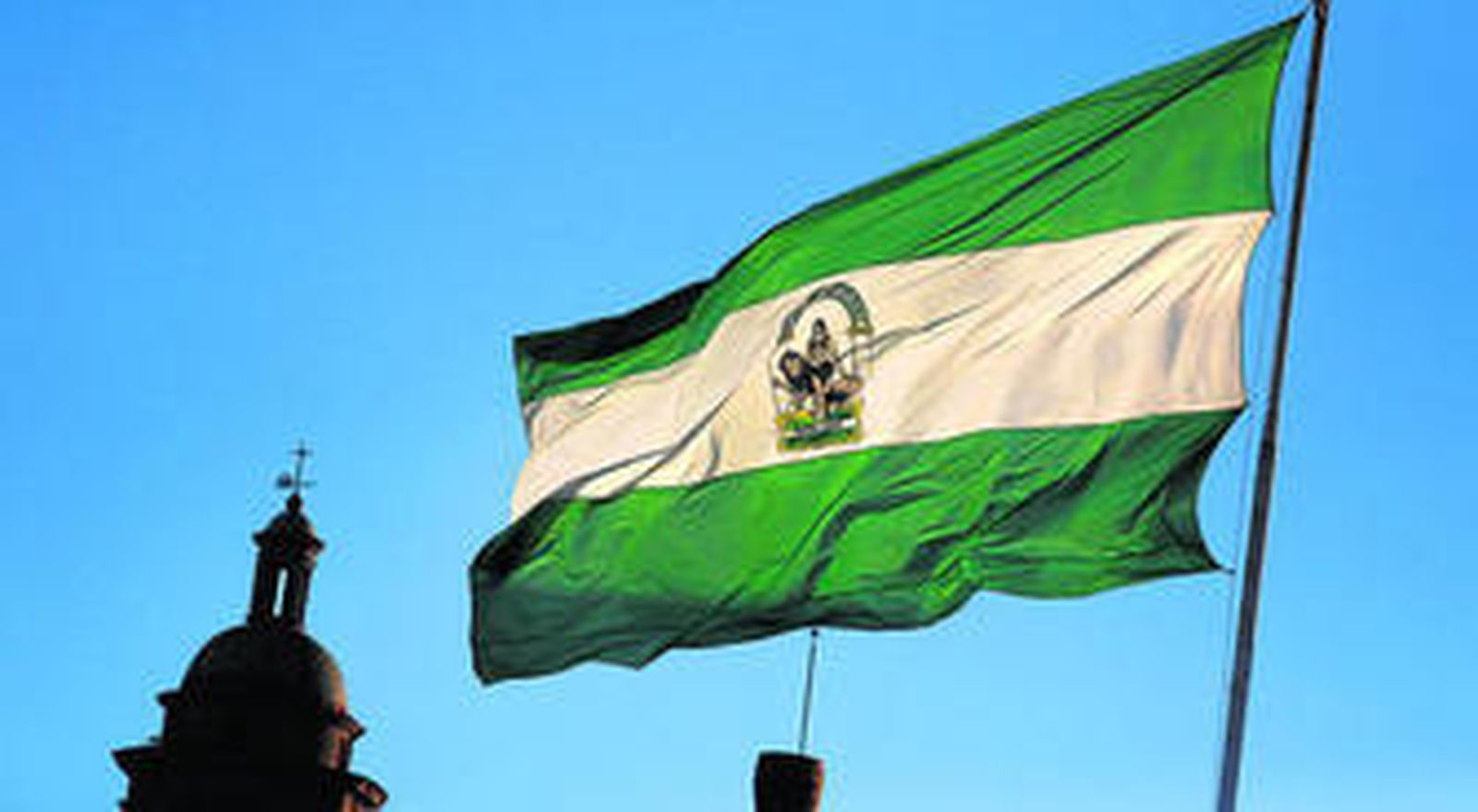 La gran bandera de Andalucía que ondea desde el pasado 28 de febrero en el mástil de la plaza de Sevilla.