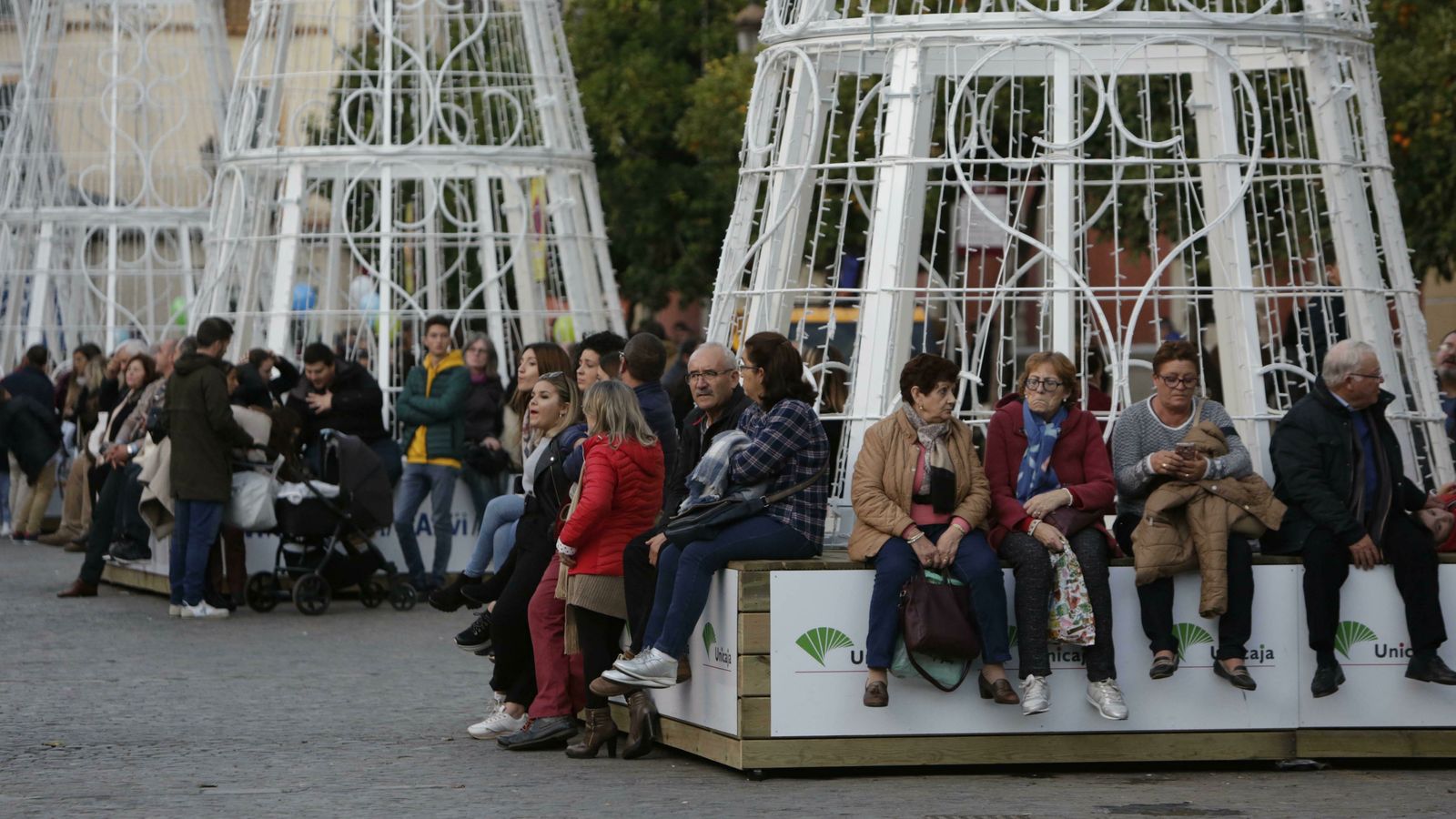 Personas esperan sentadas a que comience el espectáculo de la Plaza de San Francisco.