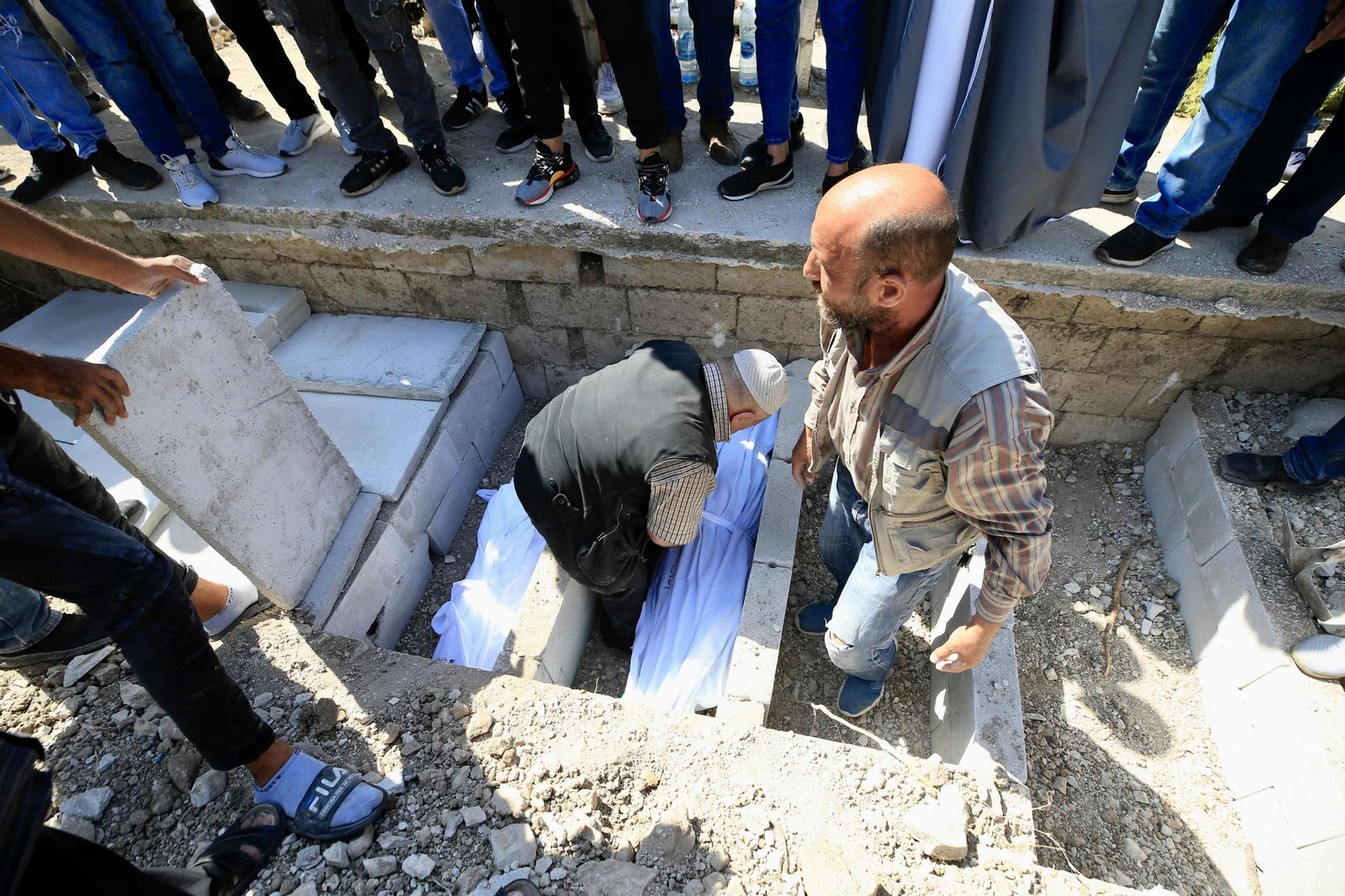 Varias personas entierran a víctimas de un bombardeo israelí en el barrio de Ain el Delb, en la ciudad libanesa de Sidon.