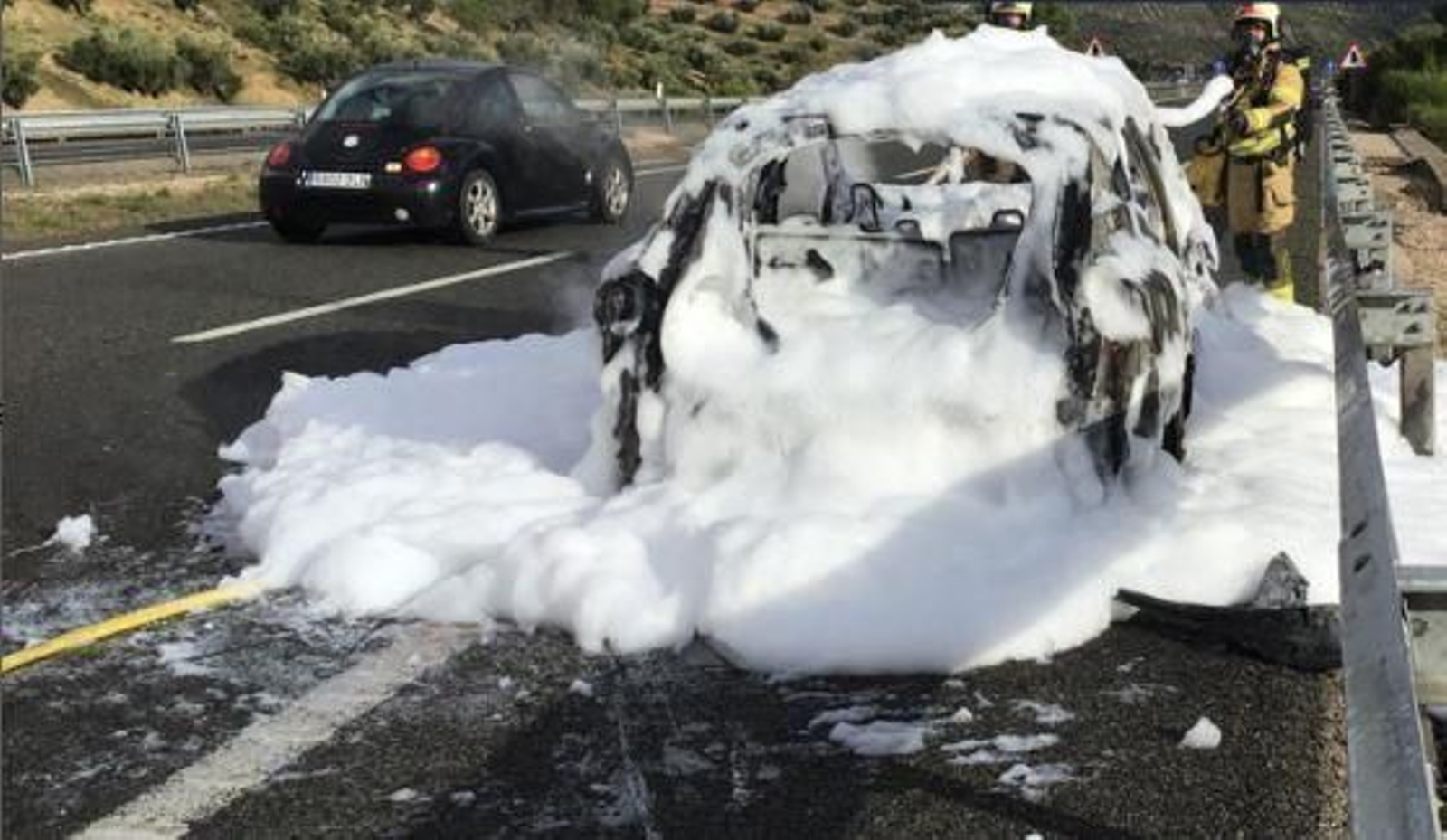 Los bomberos apagan un coche que ardía en la A-44
