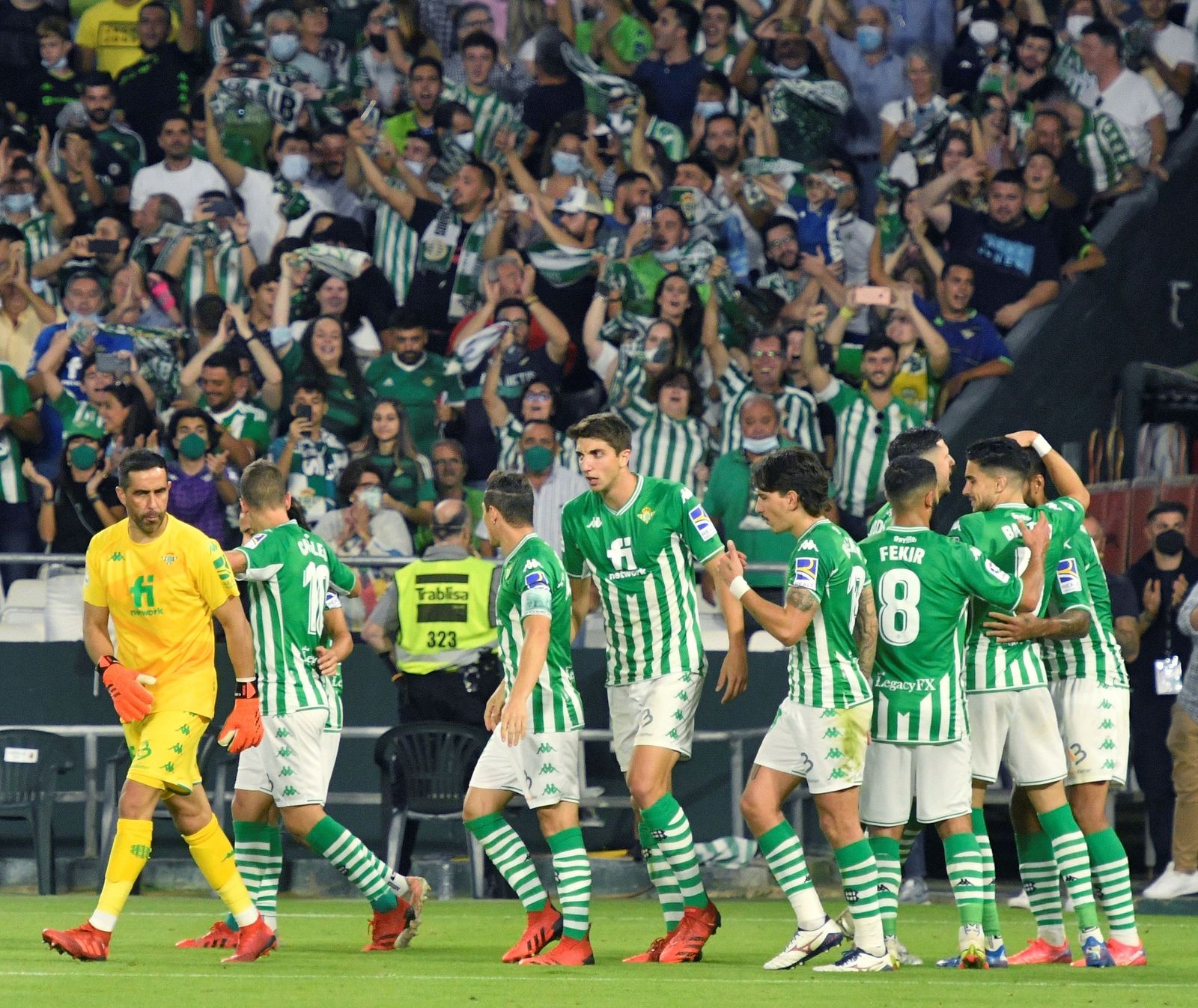 Los jugadores del Betis celebran un gol con la afición de fondo.