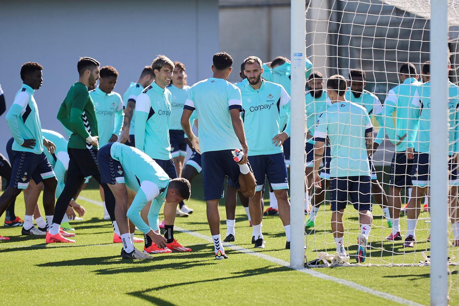 Los jugadores del Betis estiran tras el calentamiento en un entrenamiento.
