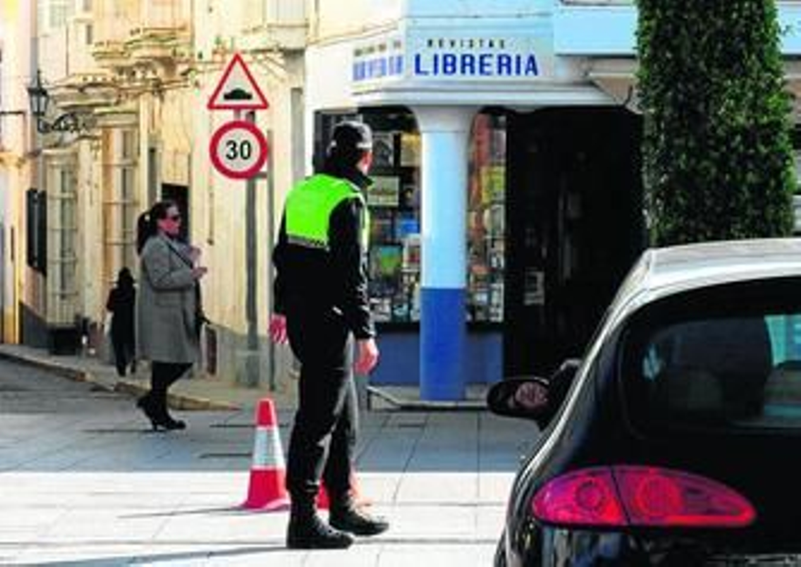 Un agente de Policía Local controla el tráfico en el cruce de la calle Real con la calle Dolores.