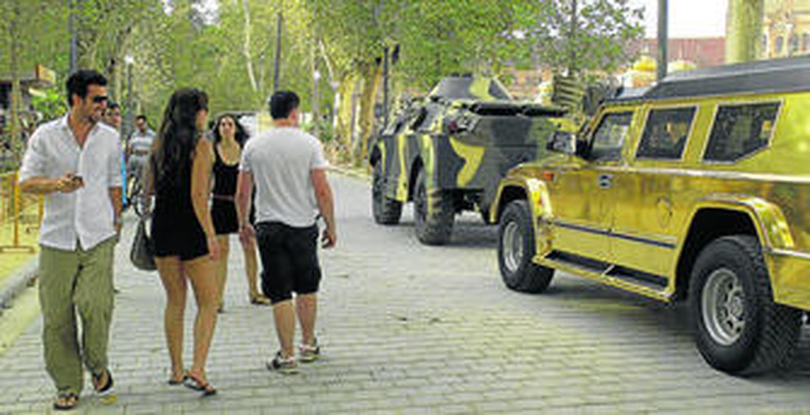 1. Unos paseantes contemplan una tanqueta con pintura de camuflaje y un todoterreno 'hummer' a las puertas de la Plaza de España. 2. El equipo técnico empezó a preparar por la tarde todo el material para los primeros planos.