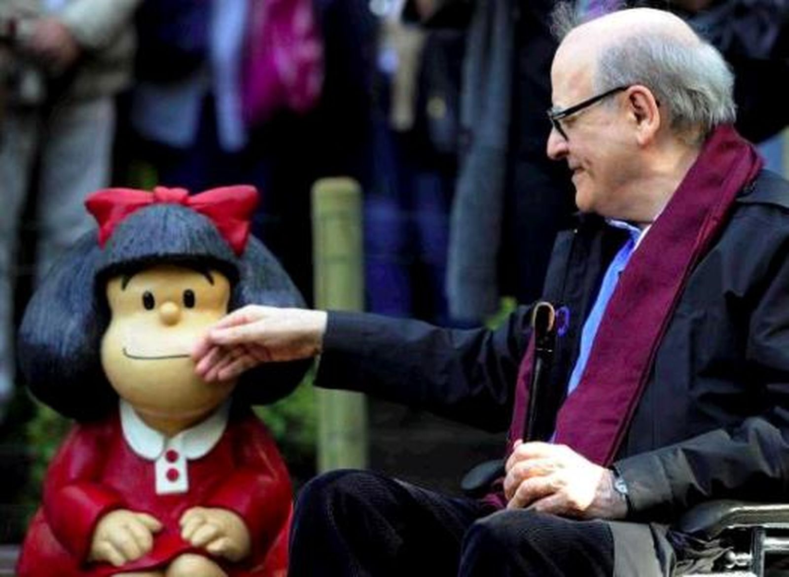 Quino, acariciando una figura de Mafalda.
