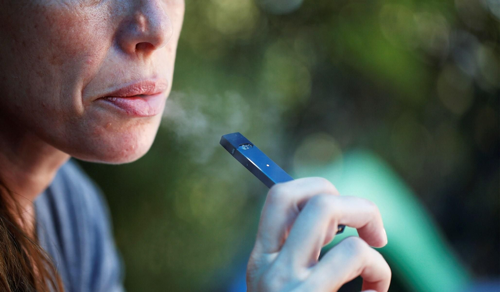 Una mujer fuma un cigarrillo electrónico.