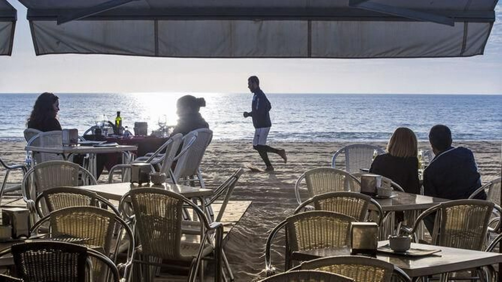 Varias personas disfrutan de un día de sol en un chiringuito de Cádiz