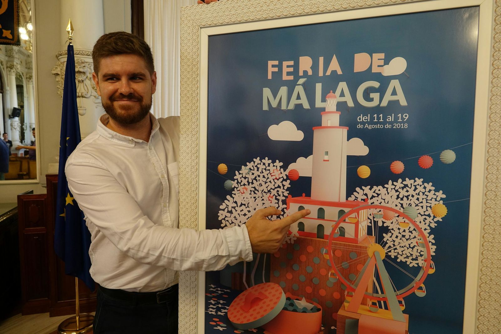 El ganador posa con el cartel de la Feria