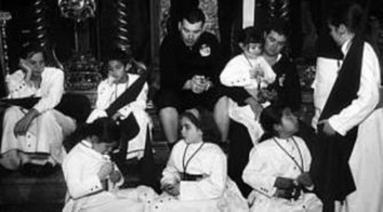 Costaleros de la Exaltación se refugian de la lluvia con un paraguas.