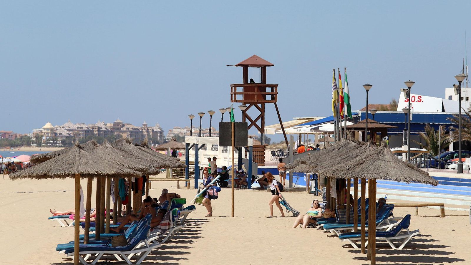 Hamacas y sombrillas a pie de paseo marítimo.