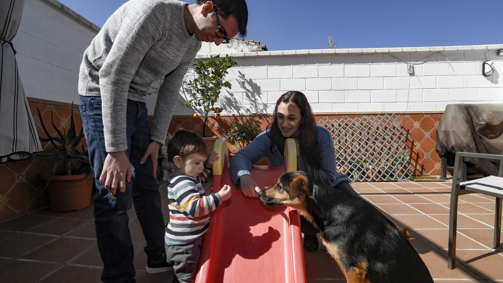 Ángel posa junto a sus padres y su perro en la terraza de casa