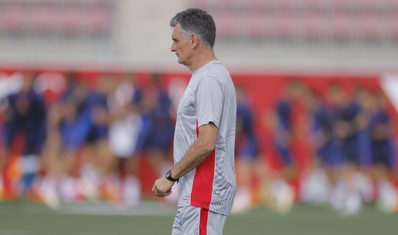 José Luis Mendilibar, en un entrenamiento del Sevilla, con la plantilla al fondo.