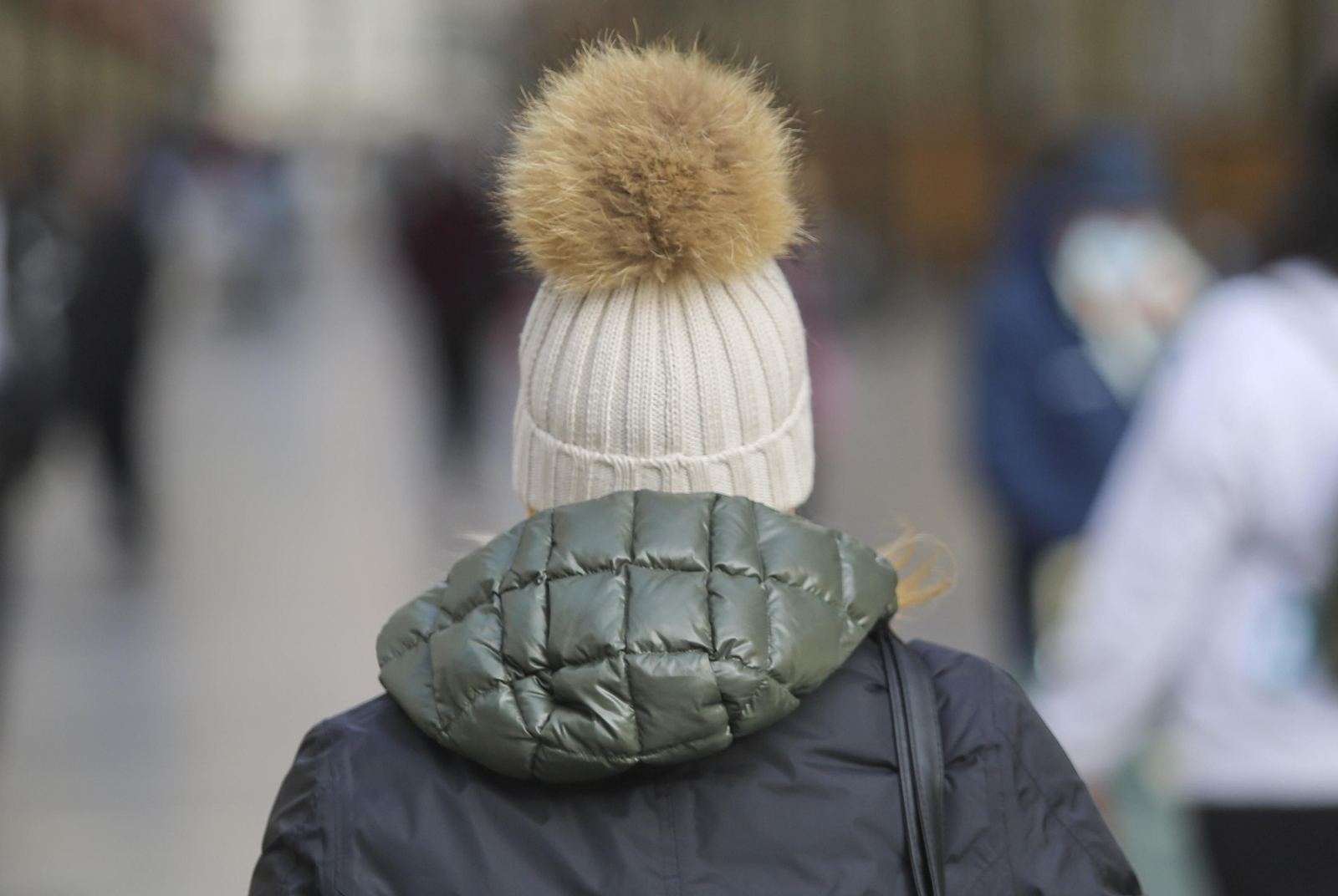 Una mujer con abrigo y gorro en Málaga.