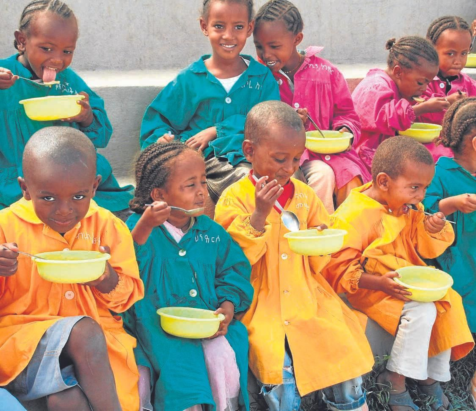 Varios niños comen gracias a un programa de Manos Unidas.