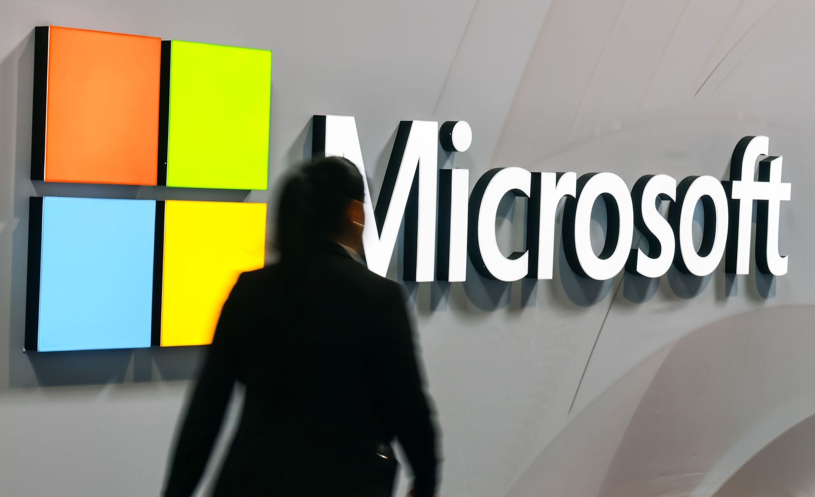 Una mujer pasa ante el logo de Microsoft.