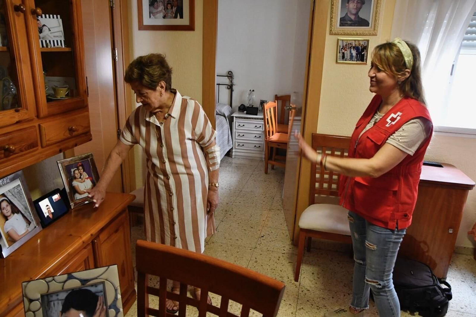 Una de las voluntarias de Cruz Roja enseña a una persona mayor a utilizar el asistente de voz.