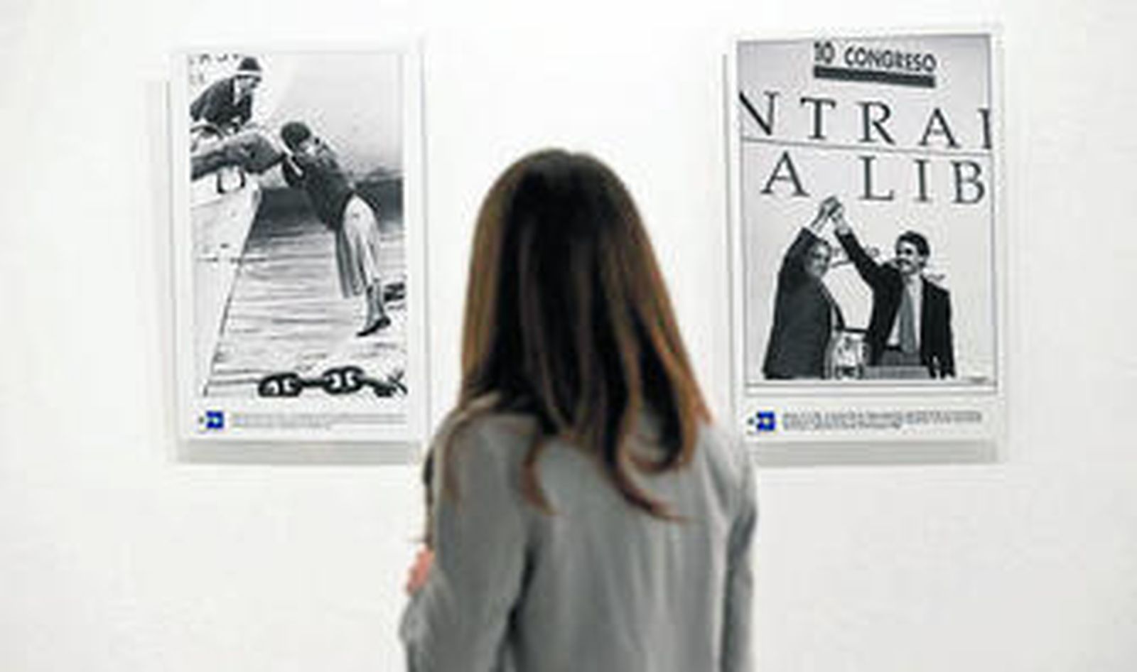 Una visitante observa dos fotografías de la exposición.