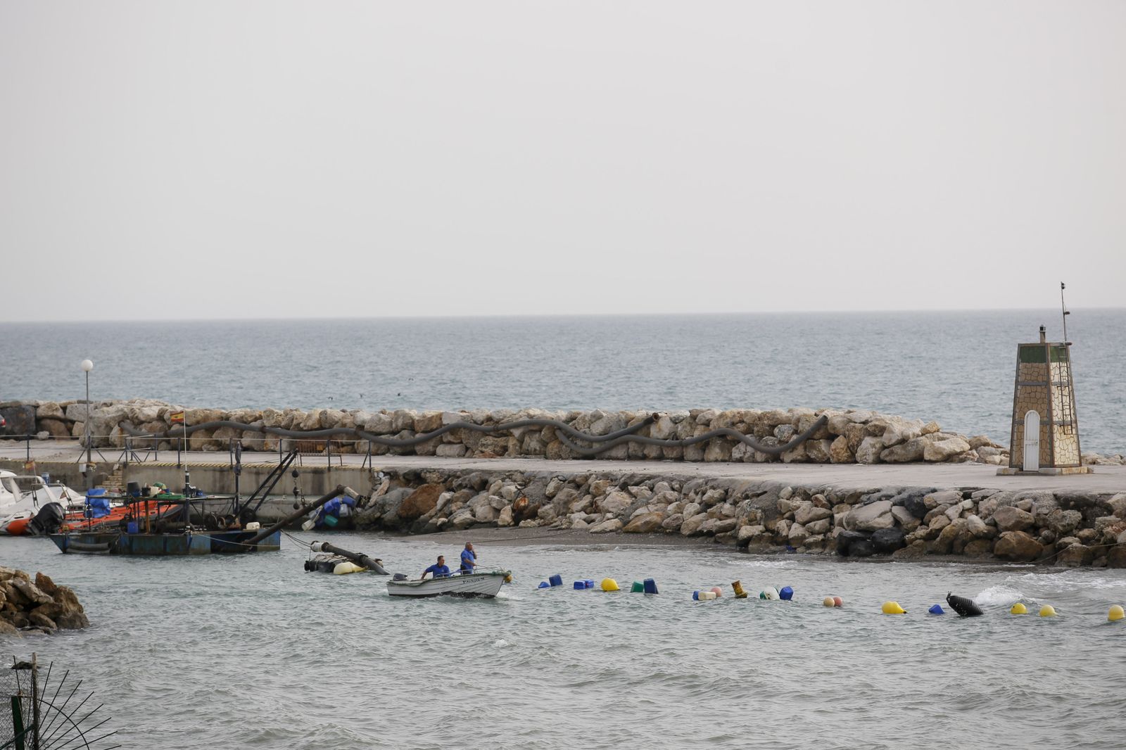 Vista de los trabajos de dragado en la bocana del puerto de El Candado, ayer.