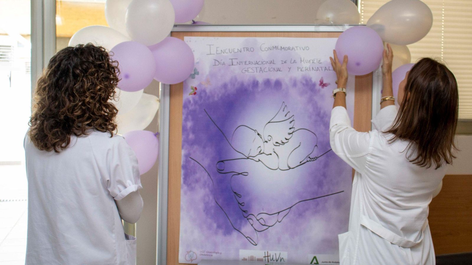 Dos enfermeras preparan el mural