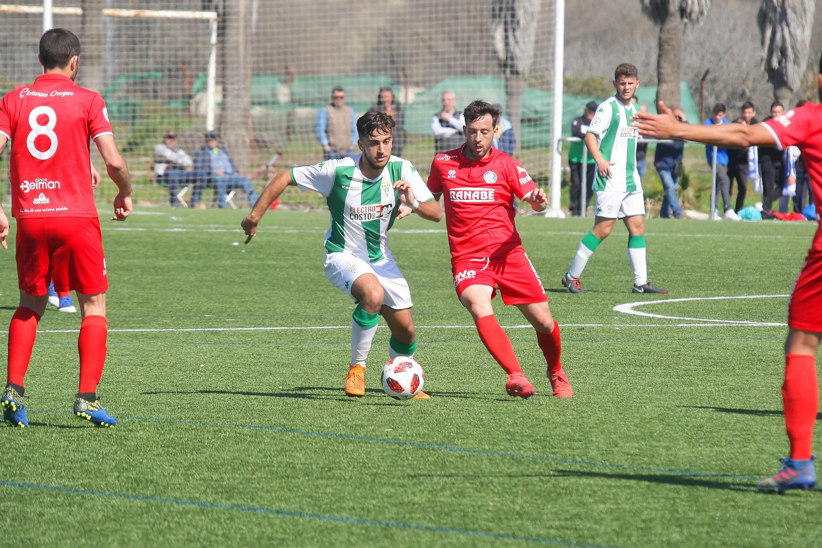 Un jugador del filial blanquiverde conduce el balón ante la presión de un xerecista.