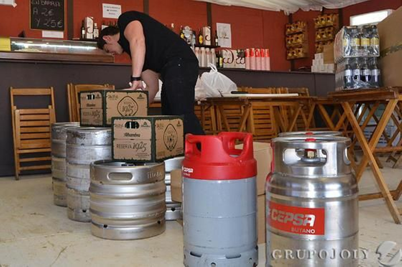 Un trabajador de la caseta La Calesera, revisando la bebida que han traído a primera hora los proveedores.  Foto: J.M Peña