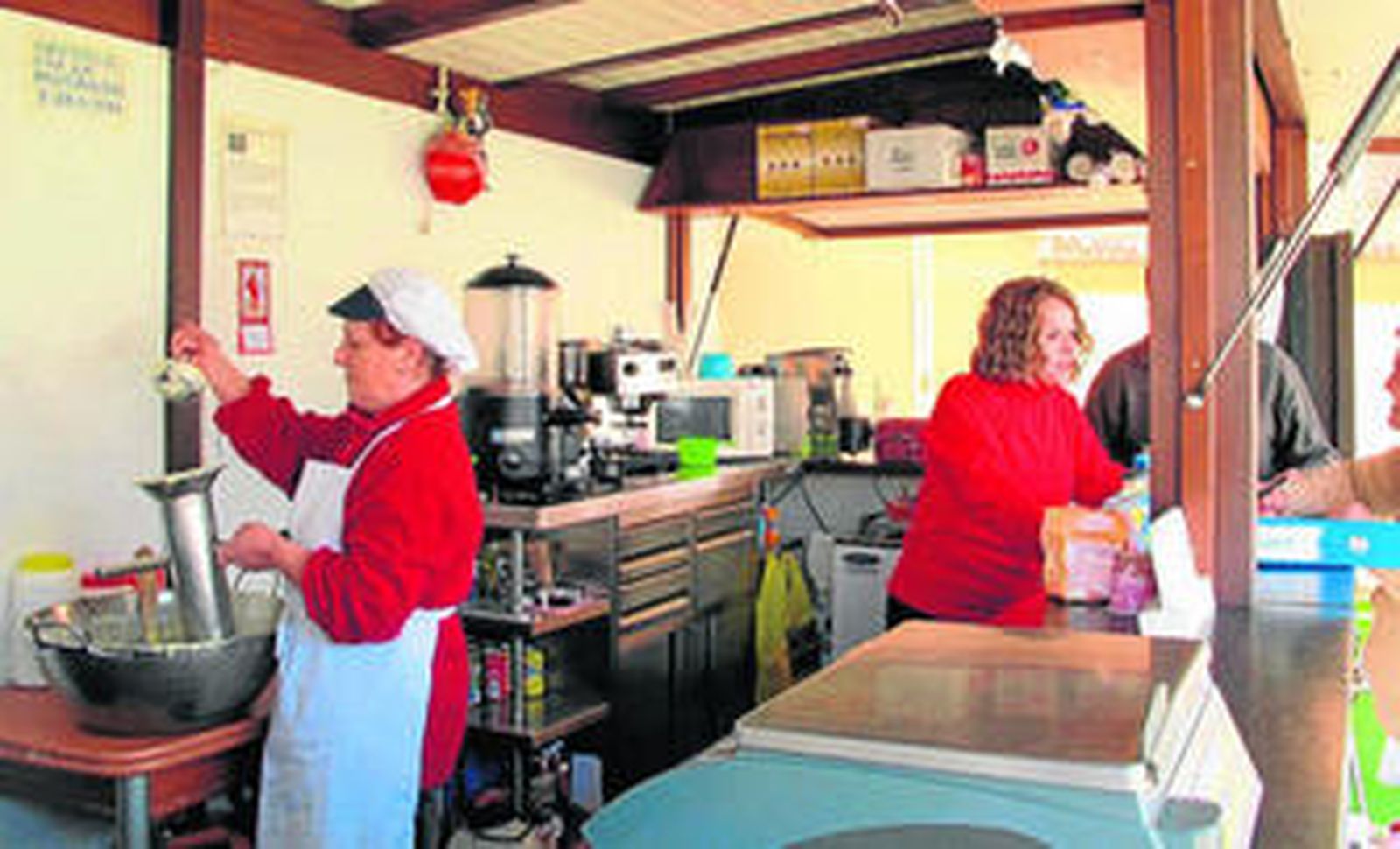 Ana María Jódaren plena faena mientras su hija María del Carmen atiende a los clientes