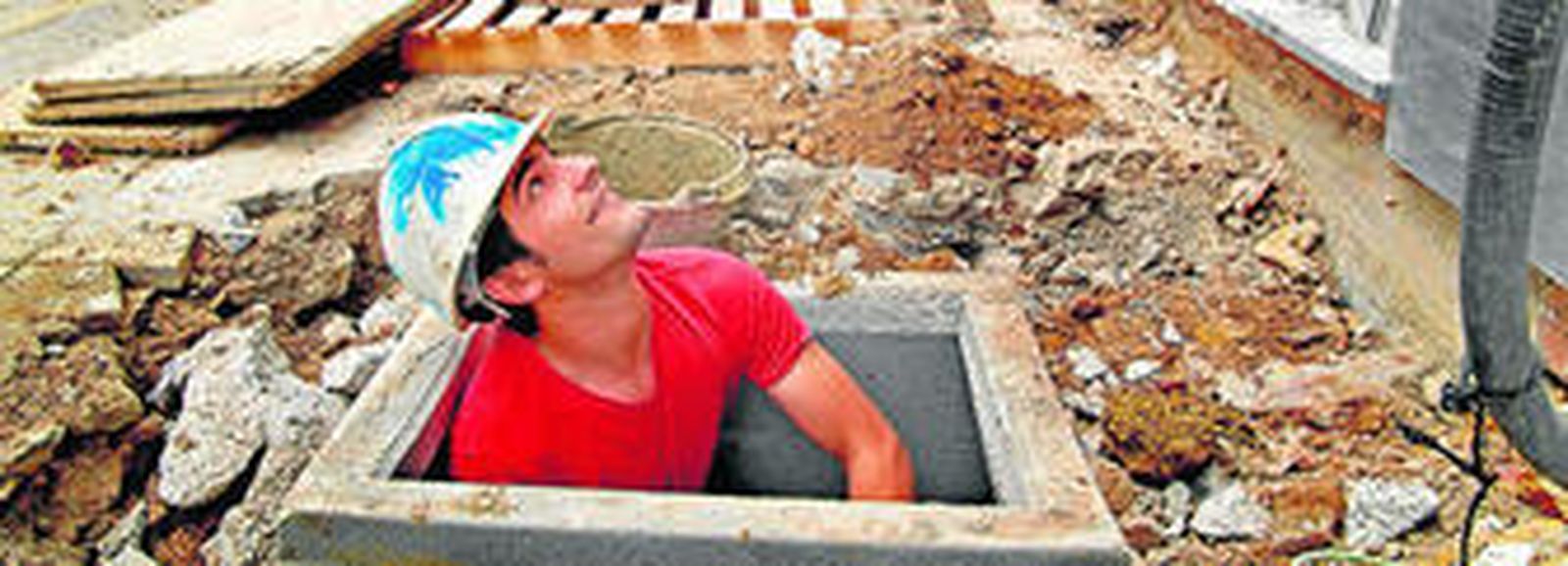 Un trabajador sale de un agujero en una obra que se ha realizado en Chiclana.