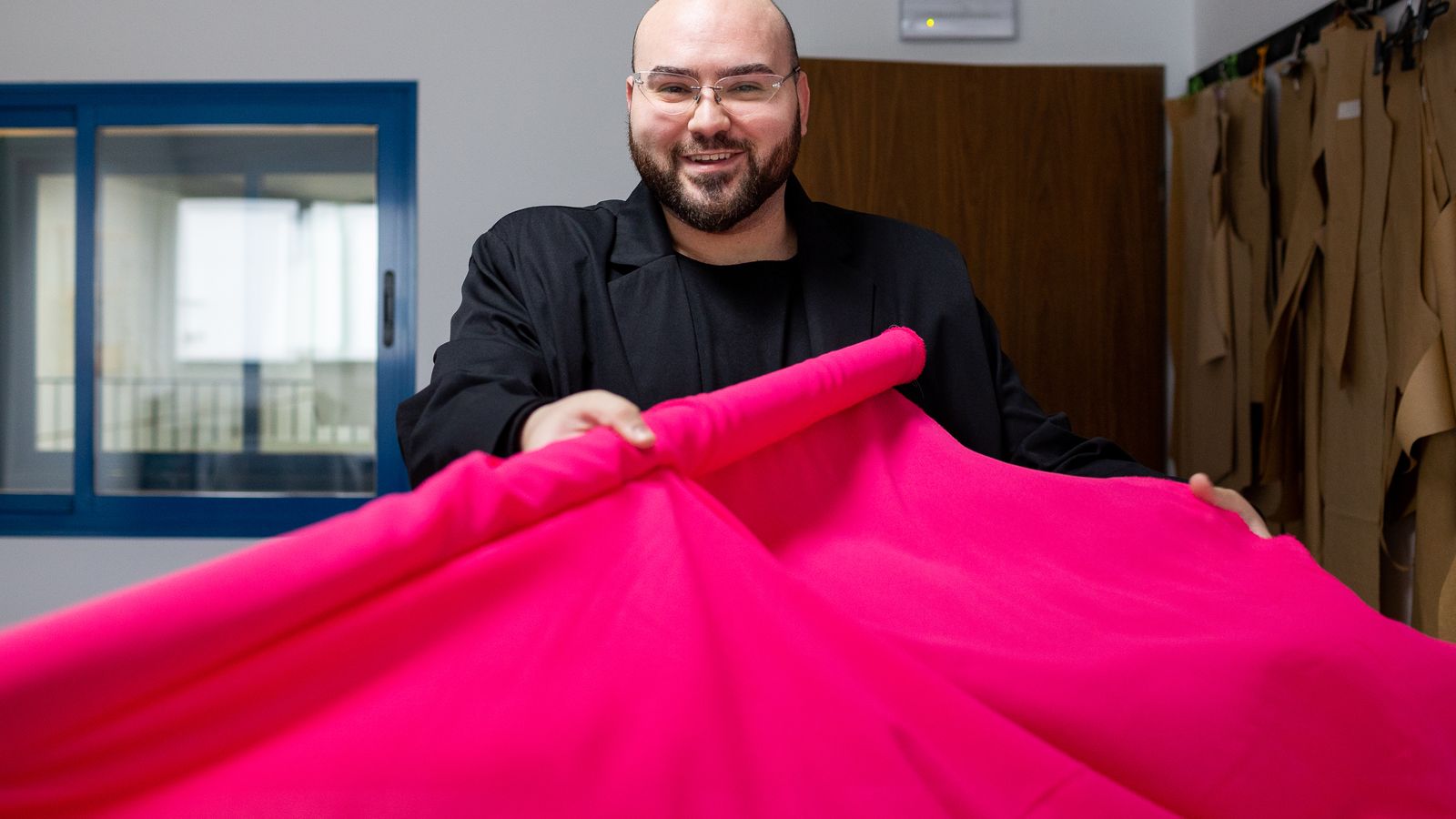 El modisto posa en su atelier con los patrones de sus próximas creaciones