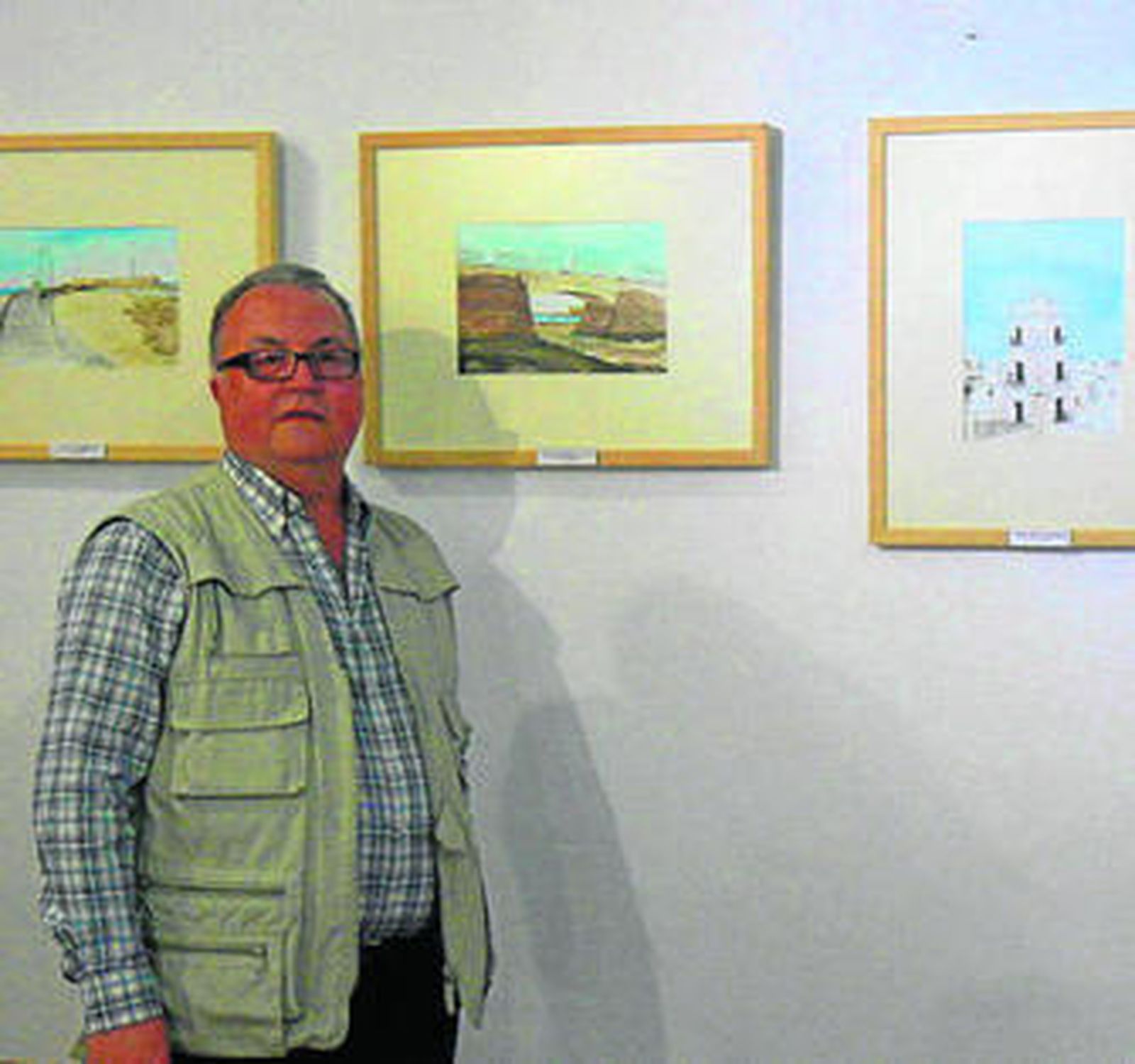 Manuel Alcina Sánchez, ante algunos de sus cuadros.