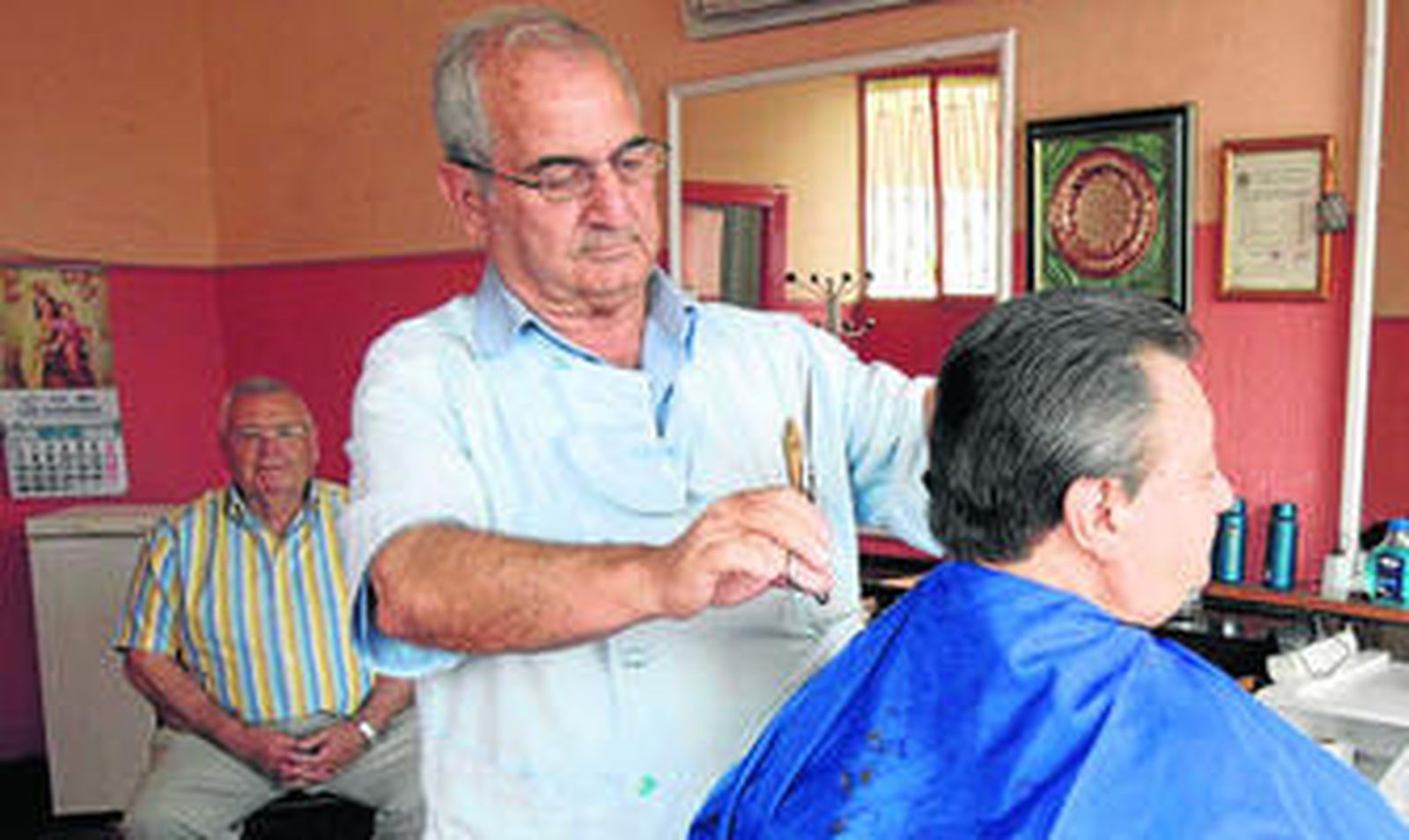 Antonio Uclés corta el pelo a Juan Martínez 'El Cartucho', compañero en el proceso de aprendizaje del arte de pelar,