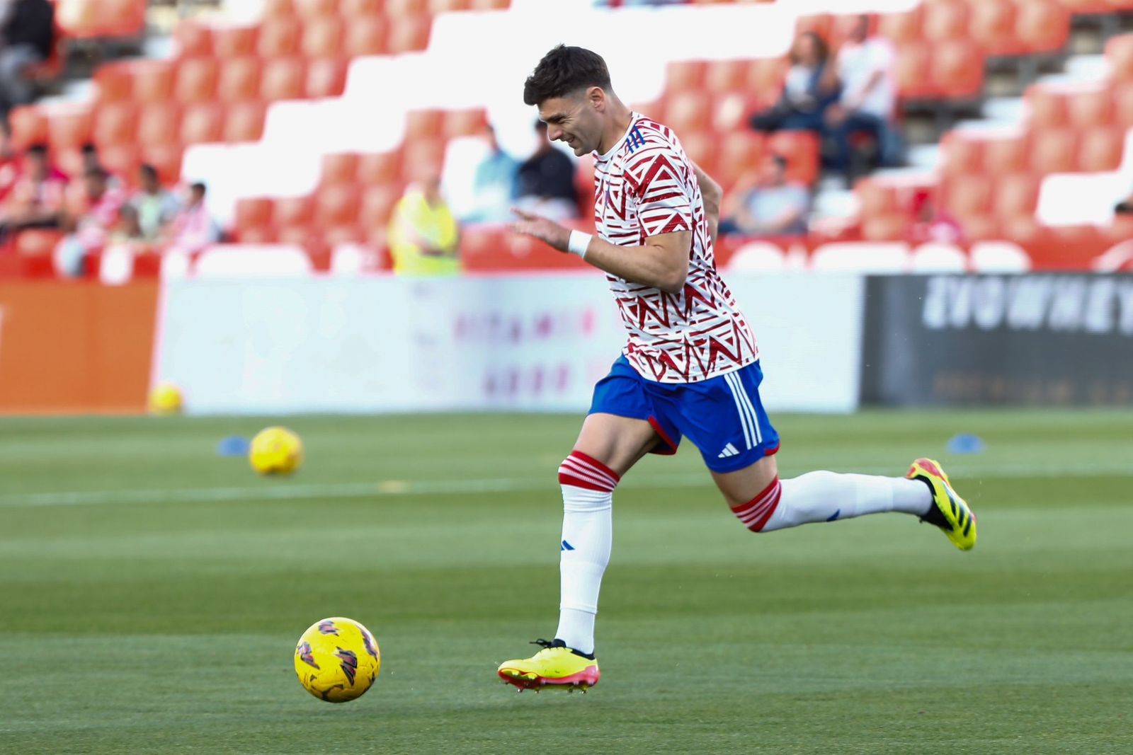 Lucas Boyé calienta sobre el césped de Los Cármenes.