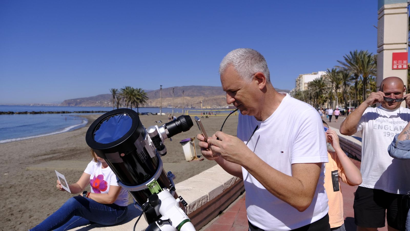 Almería observa el eclipse solar desde el Paseo Marítimo, en imágenes