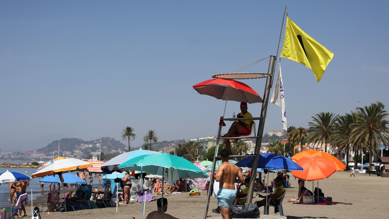 Playa de El Palo con la bandera amarilla por medusas