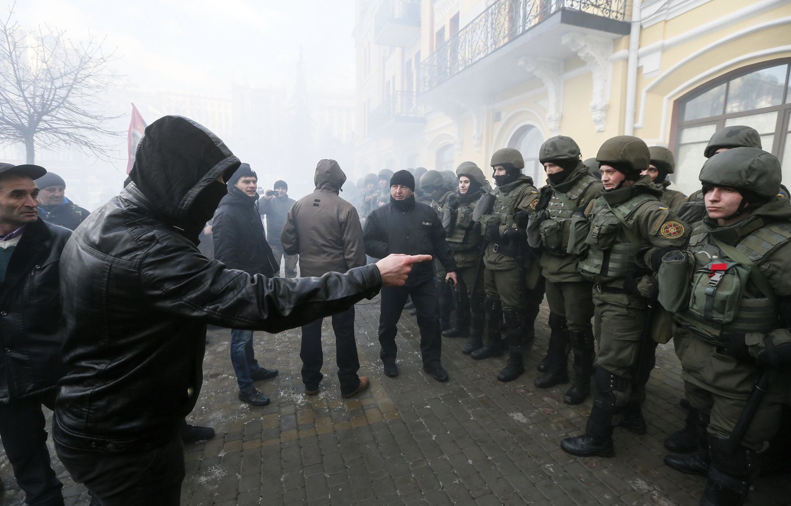 Un manifestante discutía ayer con policías durante una protesta en Kiev para reclamar que el Gobierno bloquee el comercio con los separatistas del este.