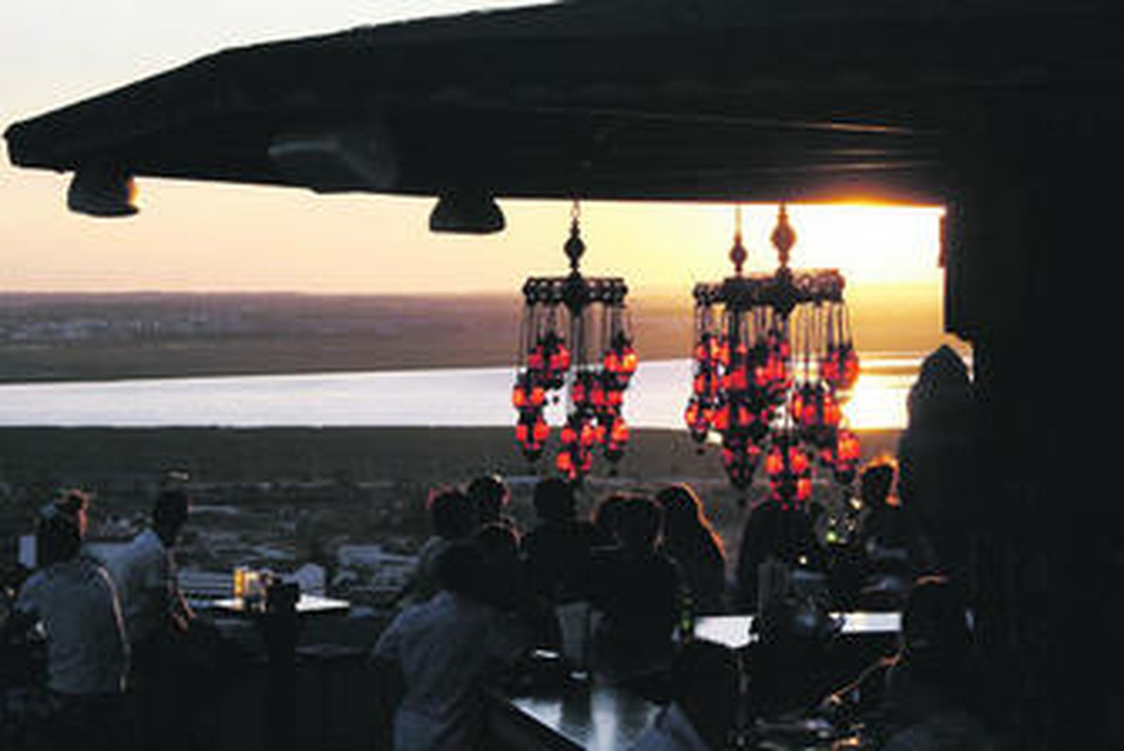 1. Una de las imágenes de Mandala, en el momento del atardecer donde se ve la ría desde una de las barras de la sala. Llama la atención la decoración hindú que le pone ambiente al local.  2. El Mosquito Club se llena de muchos adeptos que no se quieren perder el atardecer onubense al lado del mar en la playa de La Canaleta. 3. En plena Calle Ancha de Punta Umbría se encuentra Mandrágora. Todo un clásico para los onubenses que quieren vivir el bullicio de la calle principal puntumbrieña. 4. Otro de los detalles de Mandala. Un Buda adorna uno de los espacios mientras se ve la ría a lo lejos. 5. Los sábados Arena Beach se convierte en una cita ineludible para los que quieren lucir cuerpos. 6. Imponente vista de la ría de Huelva desde uno de los balcones de Mandala.  7. El interior de Mandragora sobre 21:00, cuando empieza a llenarse.
