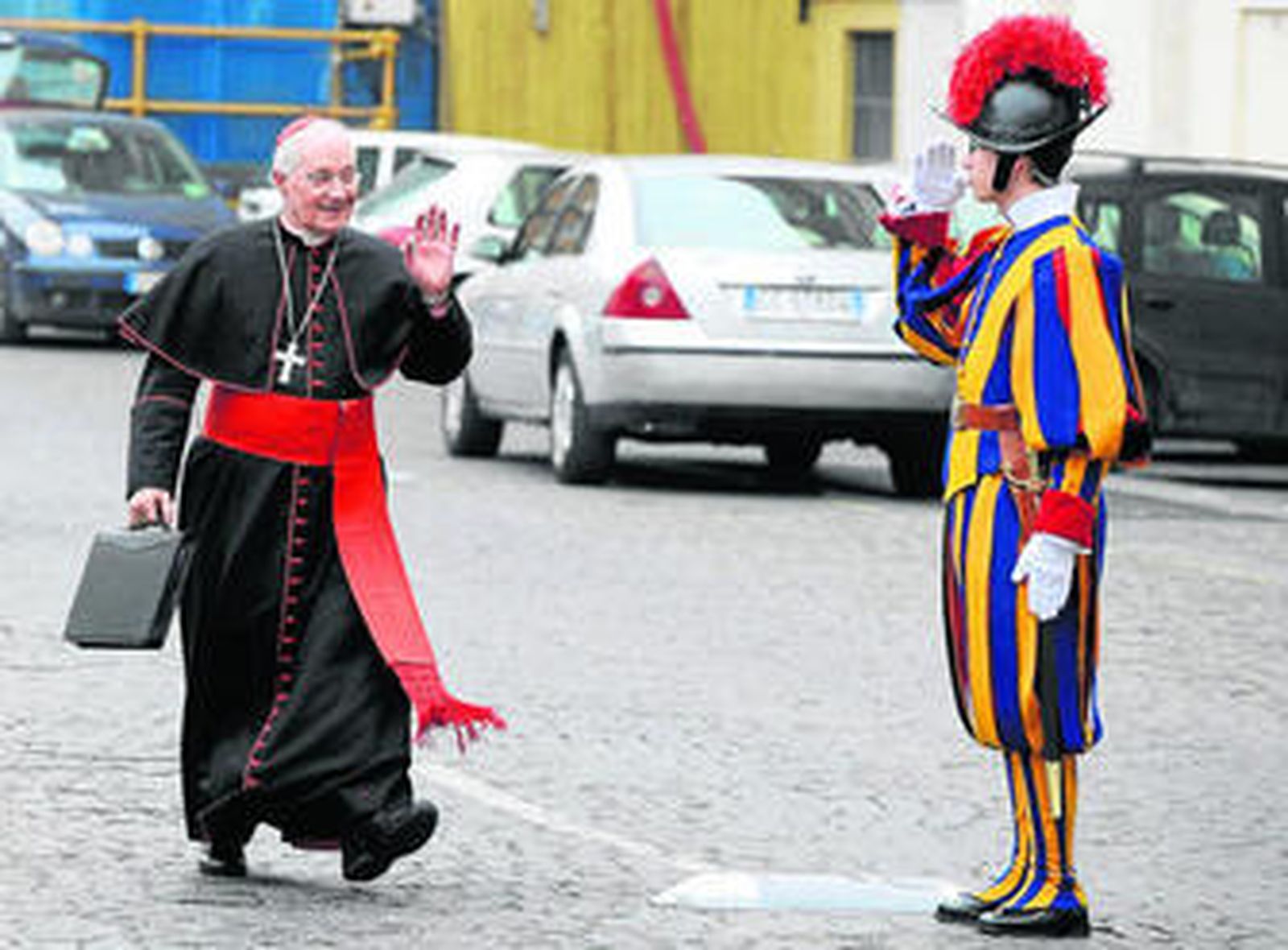 El cardenal canadiense Marc Quellet saluda a un guardia suizo a su llegada al Aula Nueva del Sínodo, en el Vaticano.