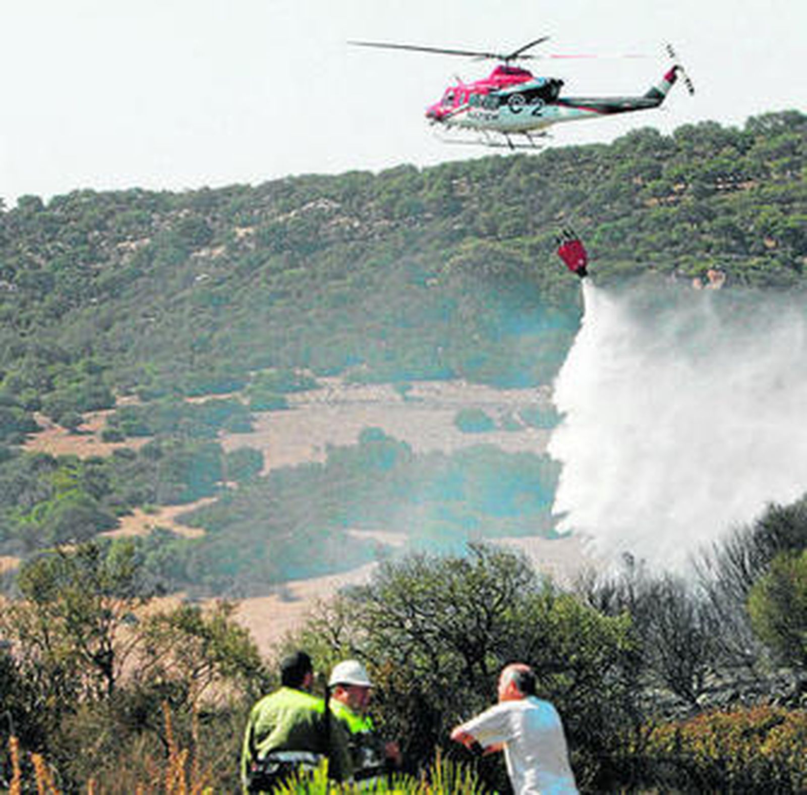 Un avión descarga agua sobre el incendio, ayer en San Roque.