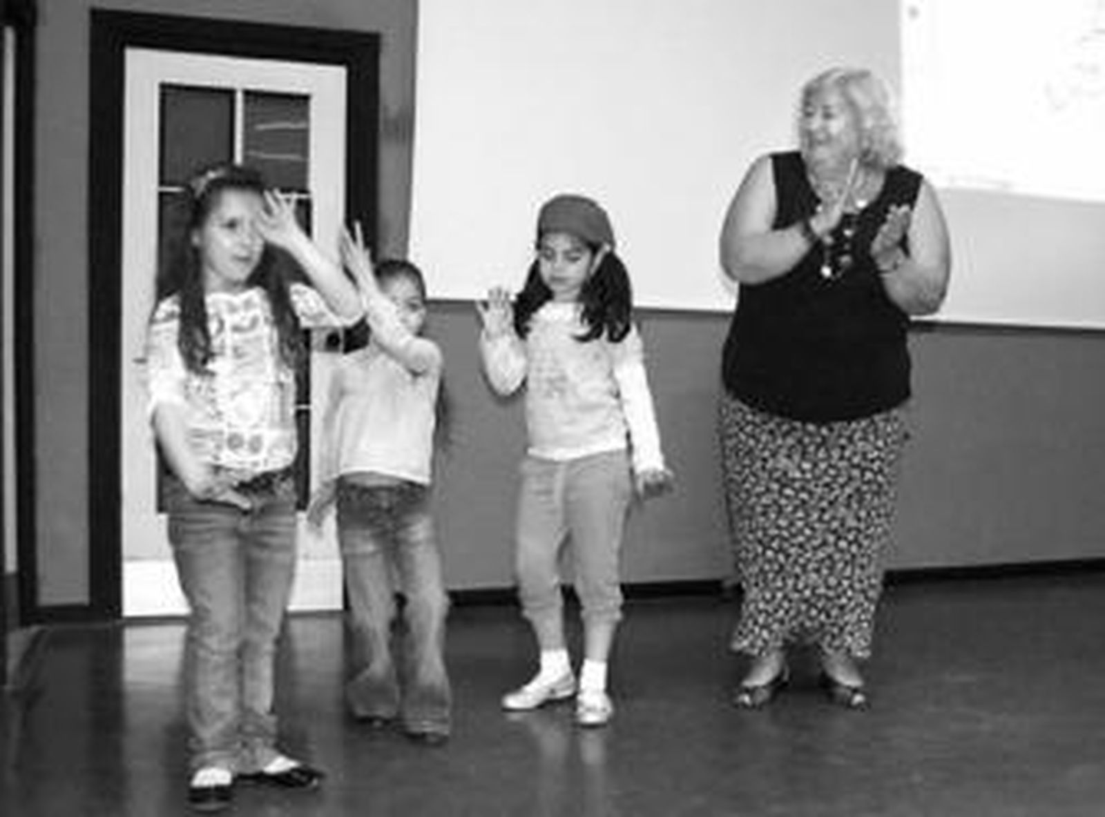 Ana María Romero Yebra con un grupo de escolares cantando en la Villaespesa.
