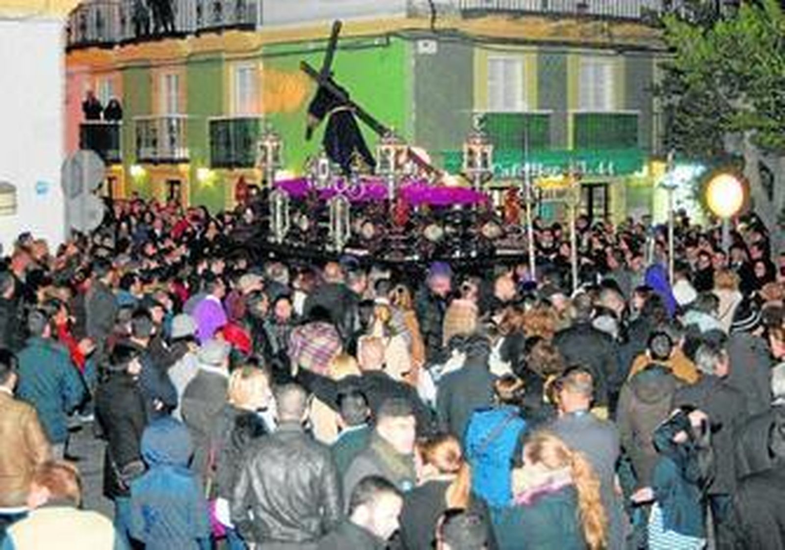 El paso del Nazareno, rodeado de una multitud, enfila la calle Las Cortes.